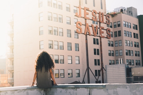 Woman & Jesus Saves Sign on Building