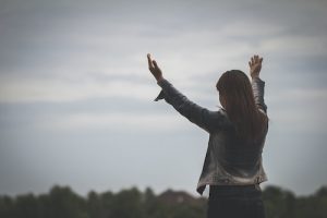 Surrender to God, hands raised in praise
